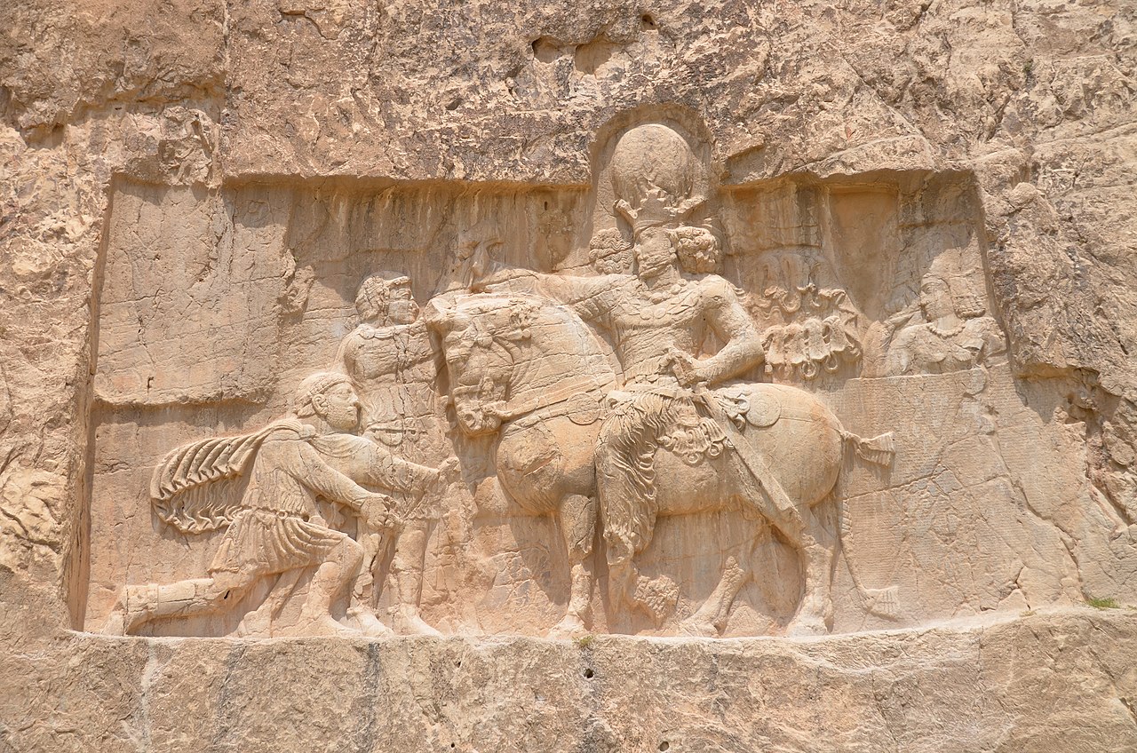 Rock relief at Naqsh-e Rostam: the captured Roman emperor Valerian kneels before the mounted Sasanian king Shapur I.